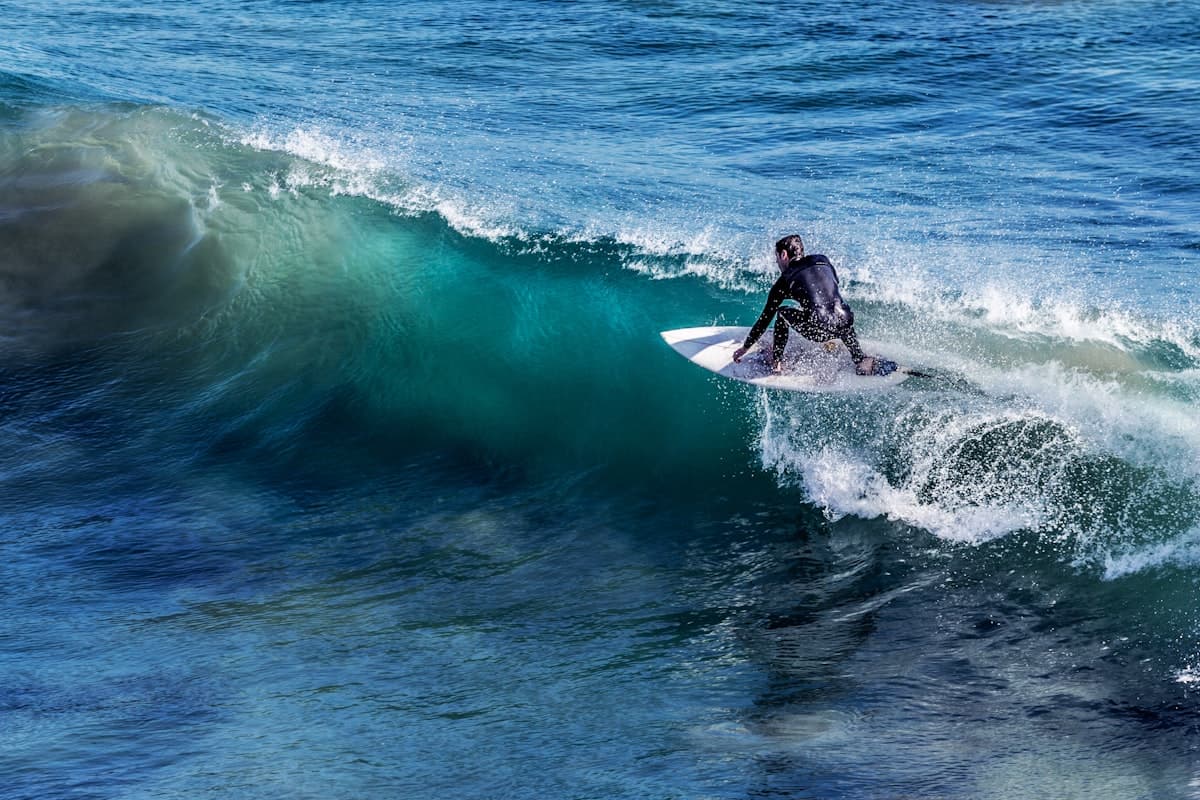 Surfer riding a wave — the payoff of consistent training on flat days