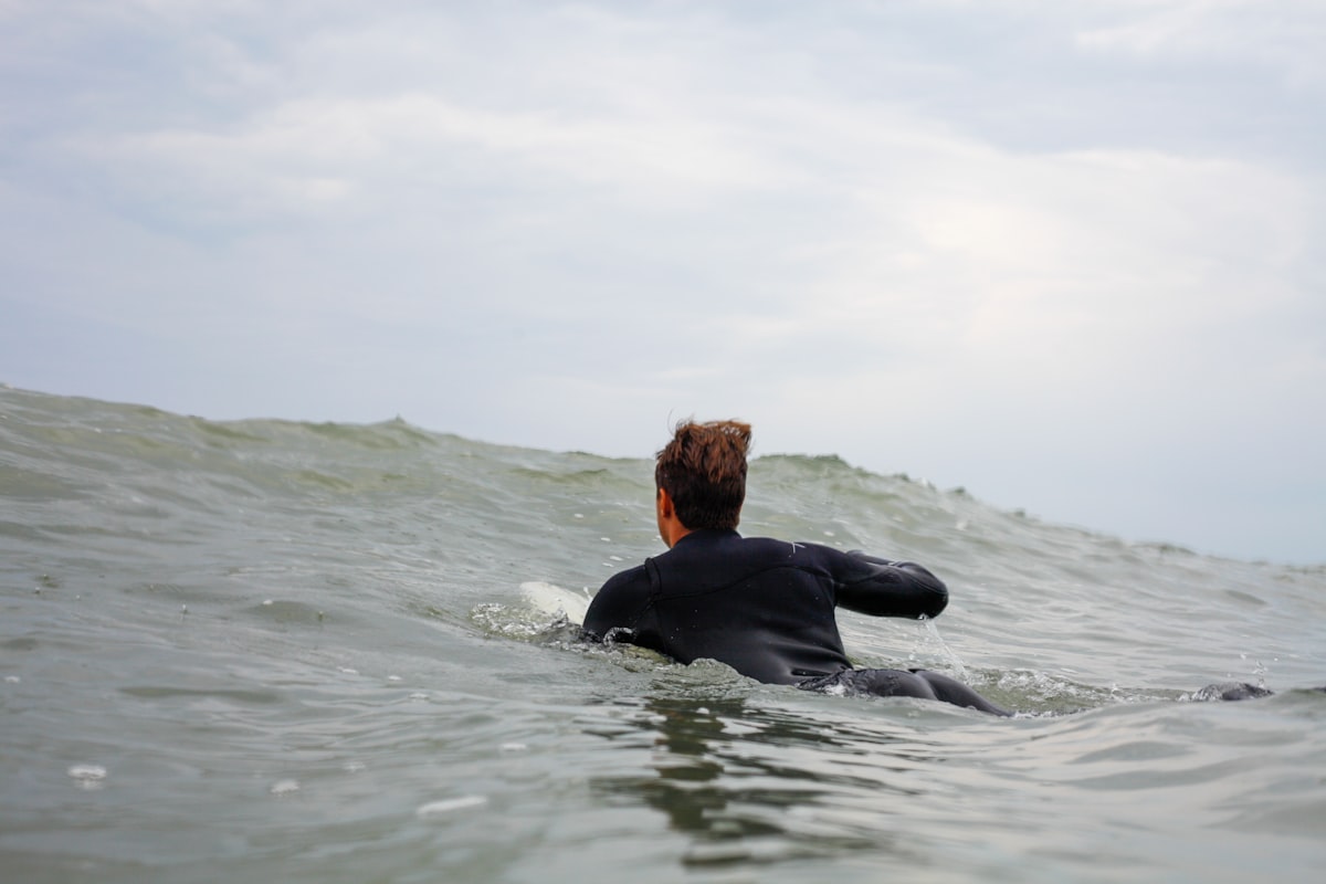 A surfer paddling through the ocean toward the lineup