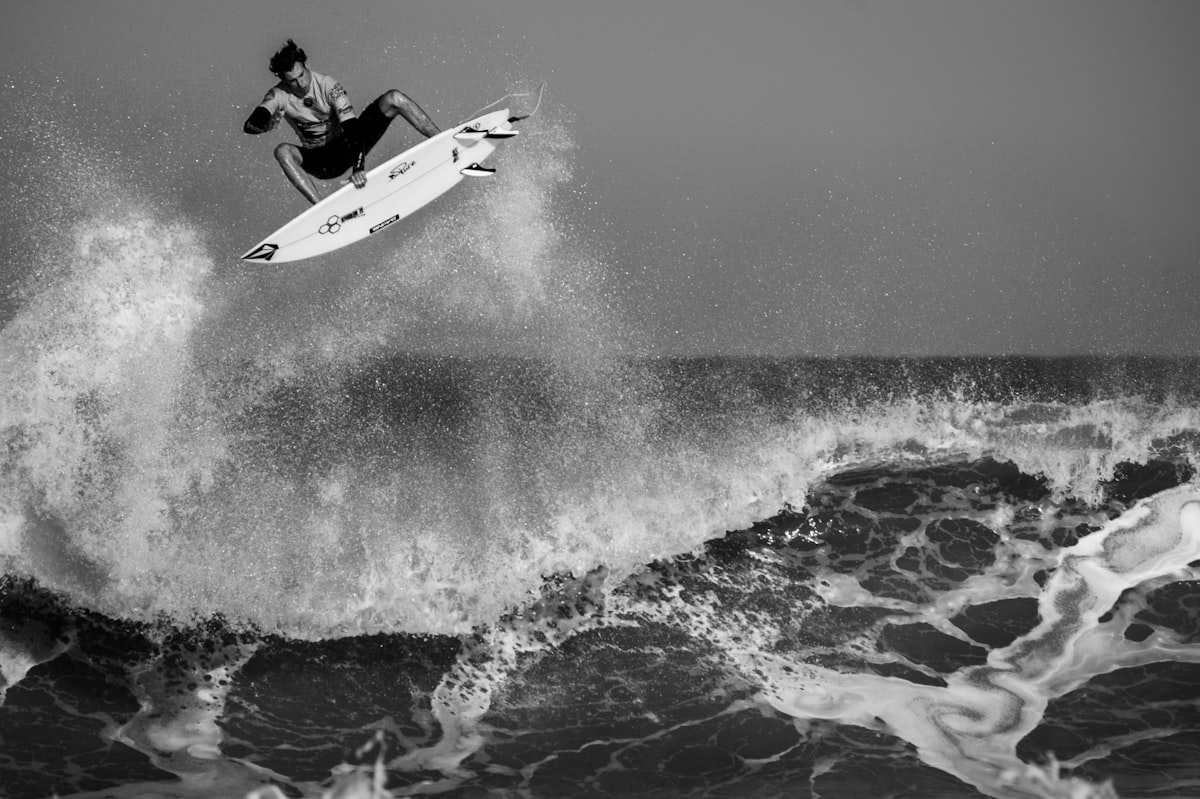 A surfer paddling out into a clean, head-high wave with a step-up under them