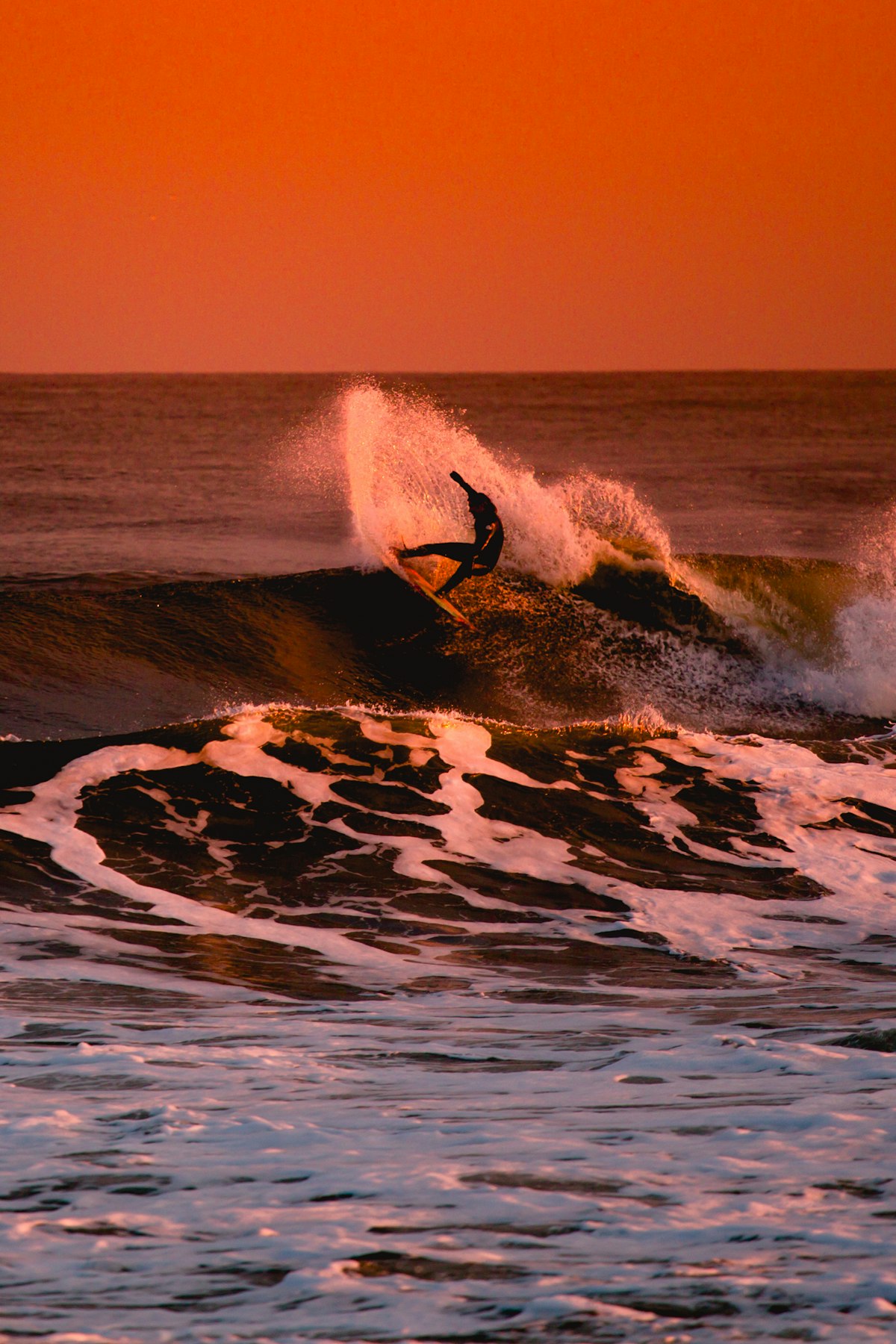 A surfer in the middle of a powerful bottom turn on the open face of a sizable wave