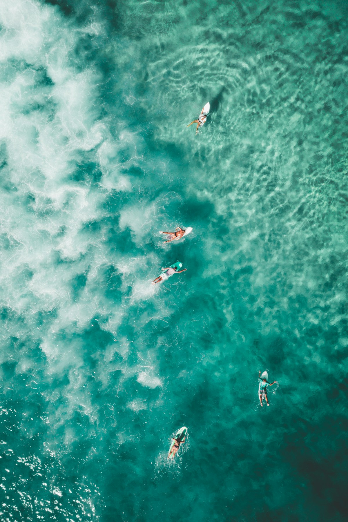 A surfer dropping into a powerful, overhead wave on a longer board