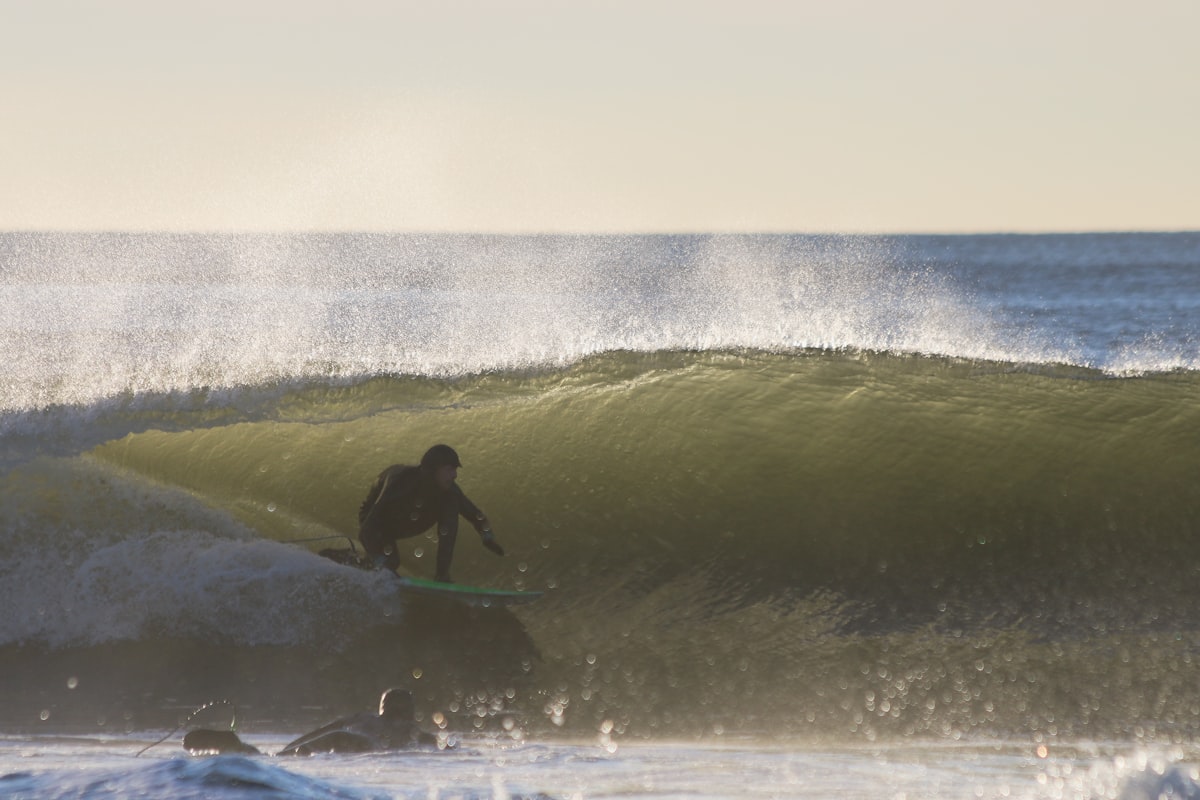 A wide view of a modern surf park with multiple surfers waiting in the lineup